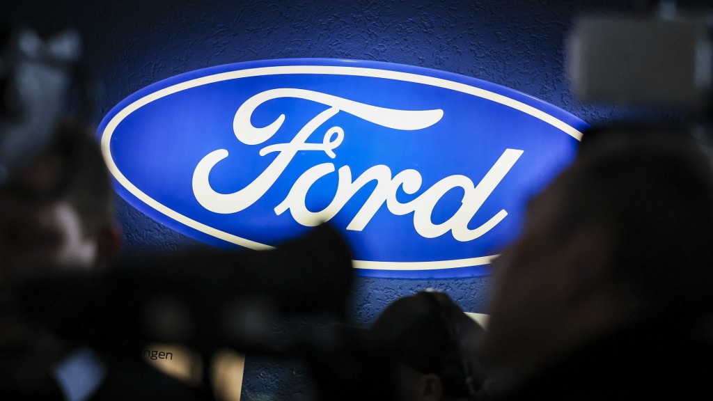 Ein beleuchtetes Firmenschild des Autobauers Ford leuchtet am Rande einer Betriebsversammlung
