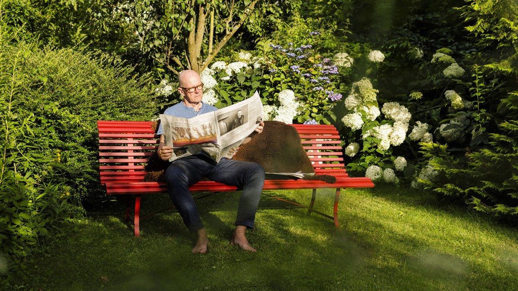 Ein Ruheständler liest eine Zeitung im Garten.