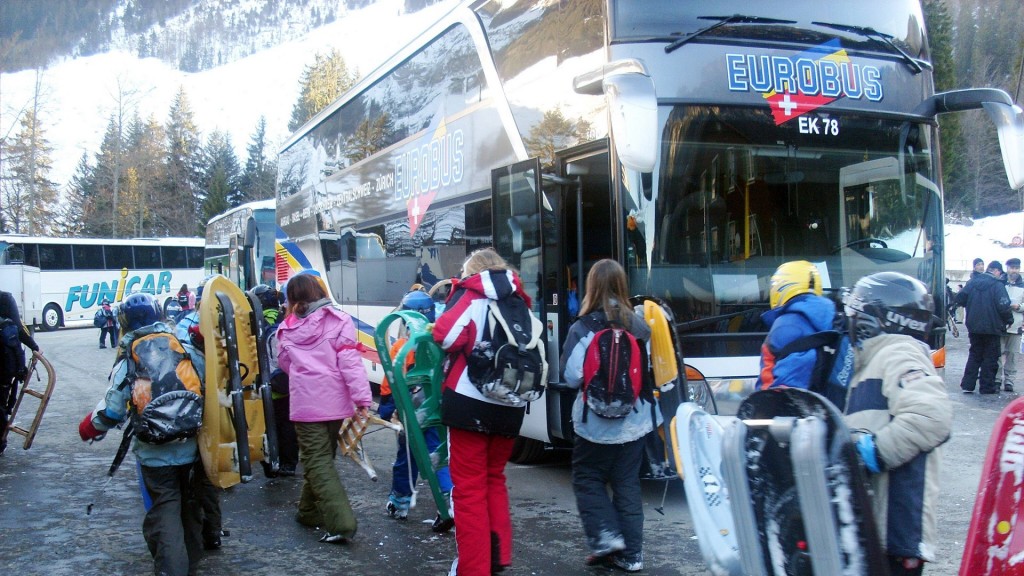 Schüler mit Schlitten auf einem Parkplatz 