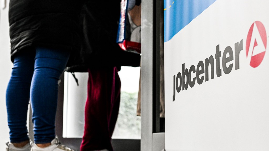 Foto: Menschen stehen am Eingang eines Jobcenters