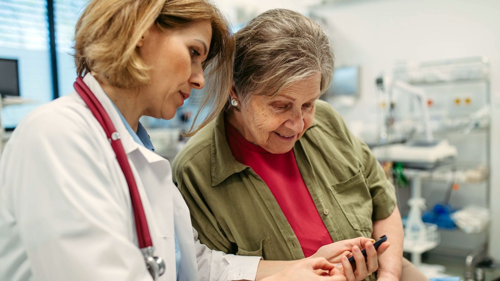 Eine Ärztin zeigt einer Patienting in der Praxis ihre elektronische Patientenakte auf dem Smartphone