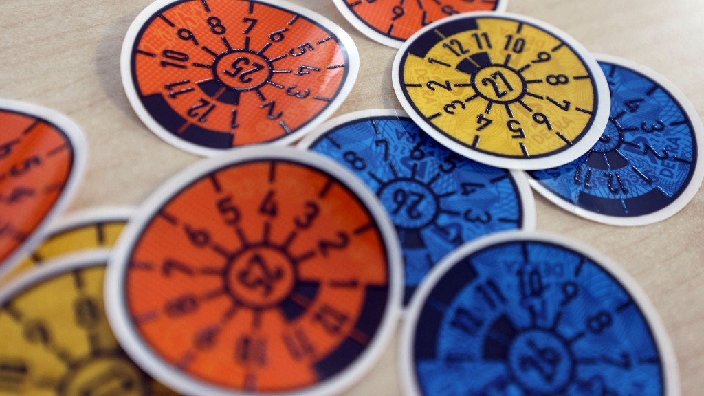 Foto: Tüv-Plaketten verschiedener Gültigkeit liegen auf einem Tisch