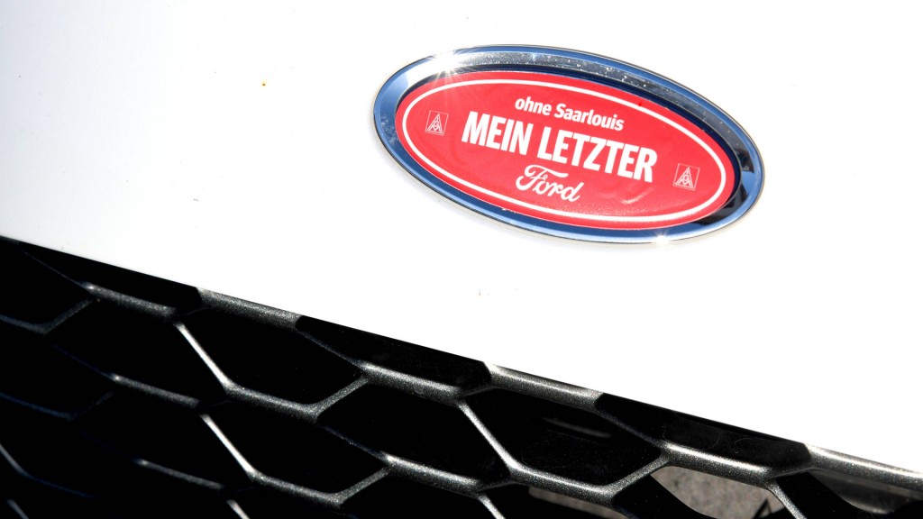 Ein Protest-Aufkleber „ohne Saarlouis – mein letzter Ford“ auf dem Marken-Emblem eines Fords