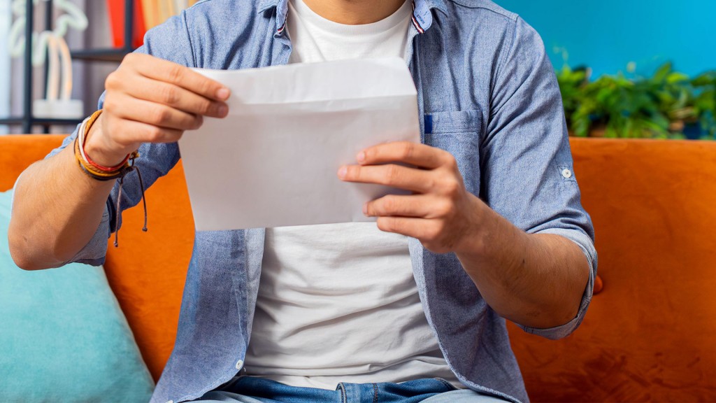 Jemand hält einen geöffneten Briefumschlag in den Händen