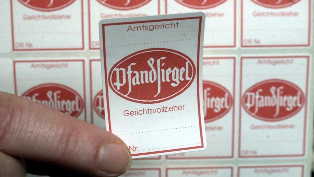 Gerichtsvollziehrr hält Pfandsiegel in der Hand