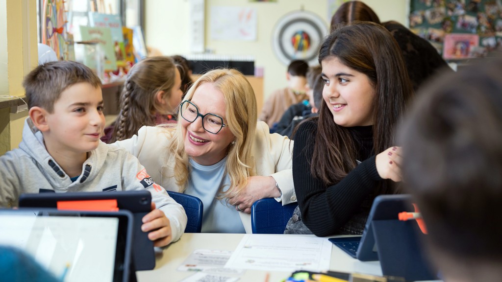 Christian Streichert-Clivot zwischen Schülern mit Tablets in der Klasse