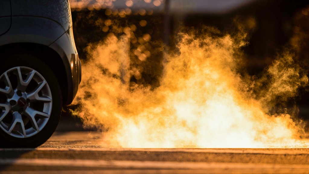 Foto: Abgase kommen im Gegenlicht der aufgehenden Sonne aus dem Auspuff eines Autos