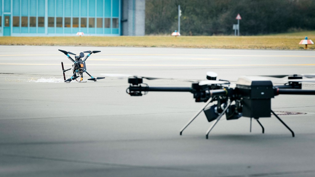 Foto: Eine Testdrohne und eine Abfangdrohne auf dem Boden vor einem Flugzeughangar