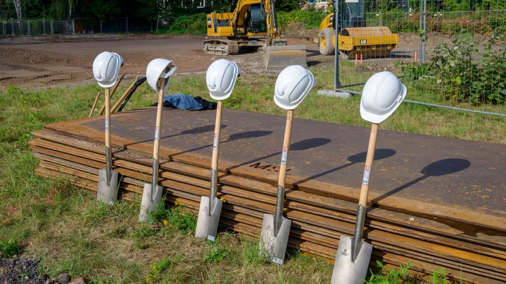 Foto: Spatenstich für ein öffentliches Gebäude. Die symbolischen Spaten mit Bauarbeiterhelmen stehen schon bereit.