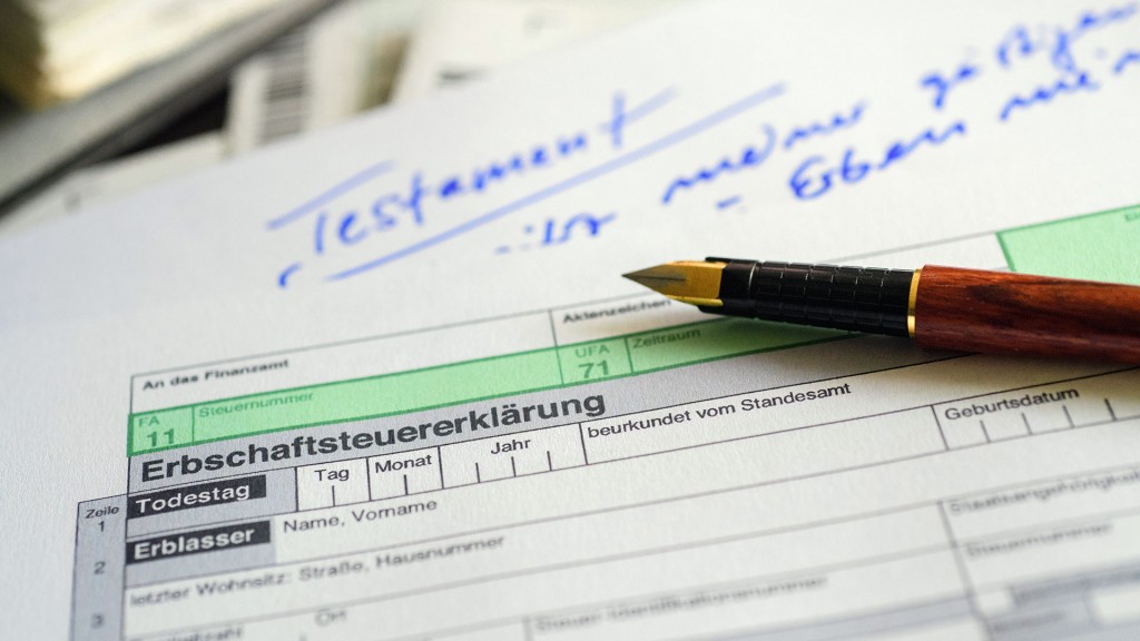 Foto: Ein Formular für die Erbschaftsteuererklärung sowie Stift und Testament liegen auf einem Tisch
