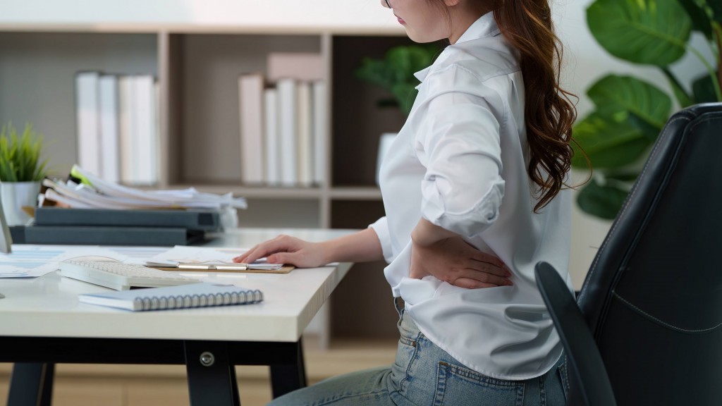 Foto: Frau mit Rückenschmerzen bei der Arbeit