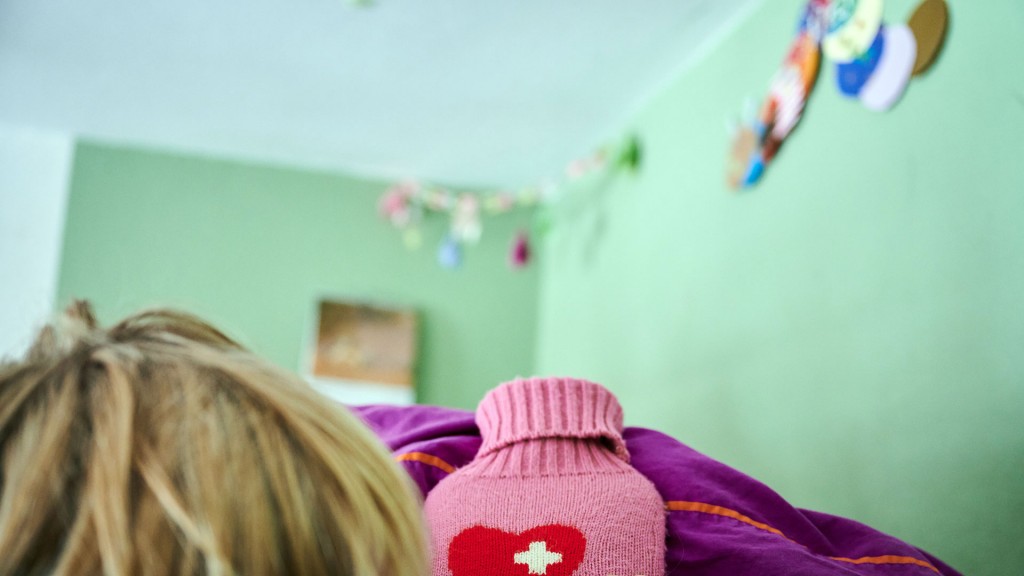 Foto: Ein krankes Kind liegt mit Wärmflasche im Bett