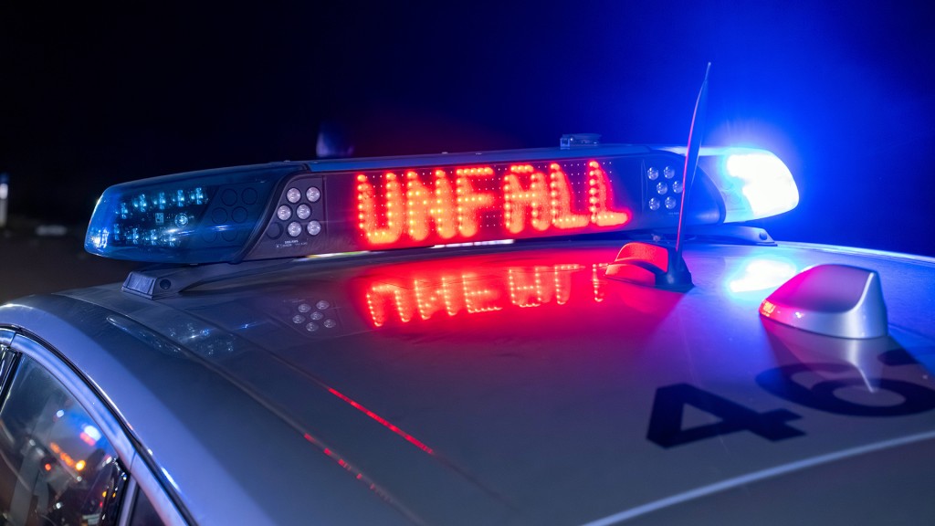 Schild auf einem Polizeiwagen warnt vor einem Unfall