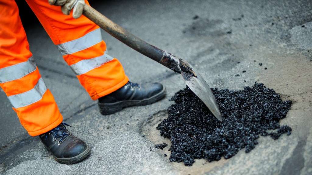 Foto: Ein Schlagloch wird notdürftig mit Asphalt ausgebessert