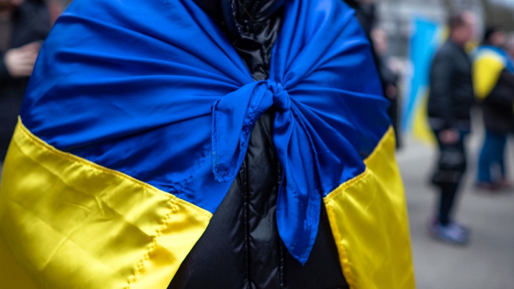 Mann mit umgebundener urkainischer Fahne
