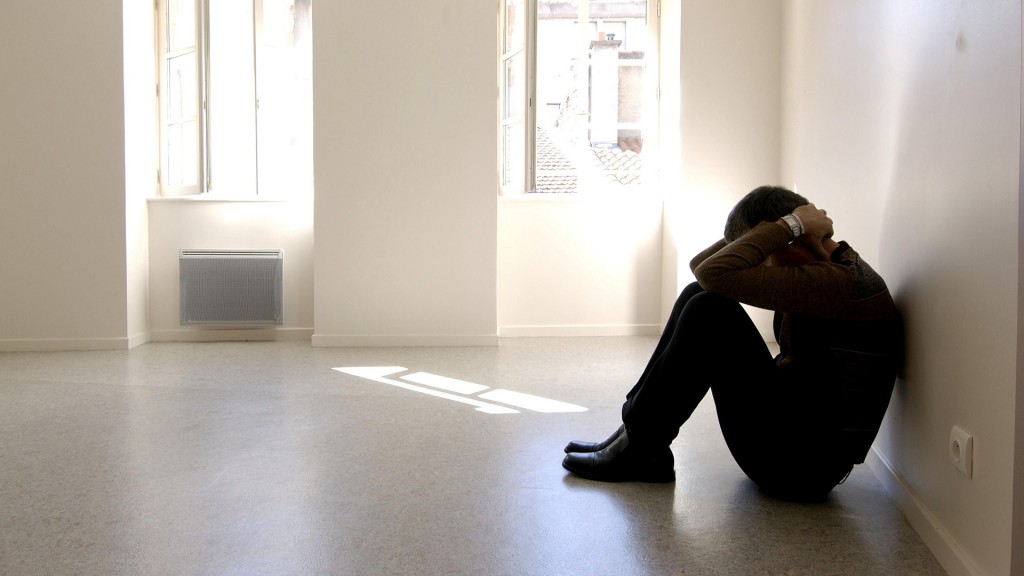 Mann kauert an einer Wand