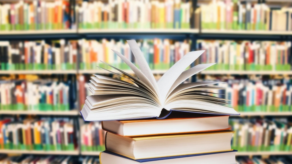 Aufgeklapptes Buch auf einem Stapel vor einem großen Bücherregal