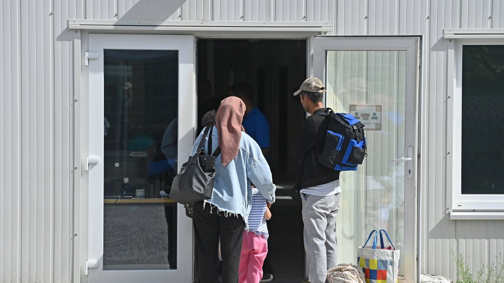 Eine geflüchtete Familie steht vor einer Unterkunft.