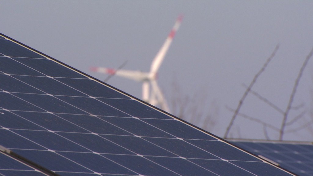 Foto: Solaranlage mit Windrädern im Hintergrund