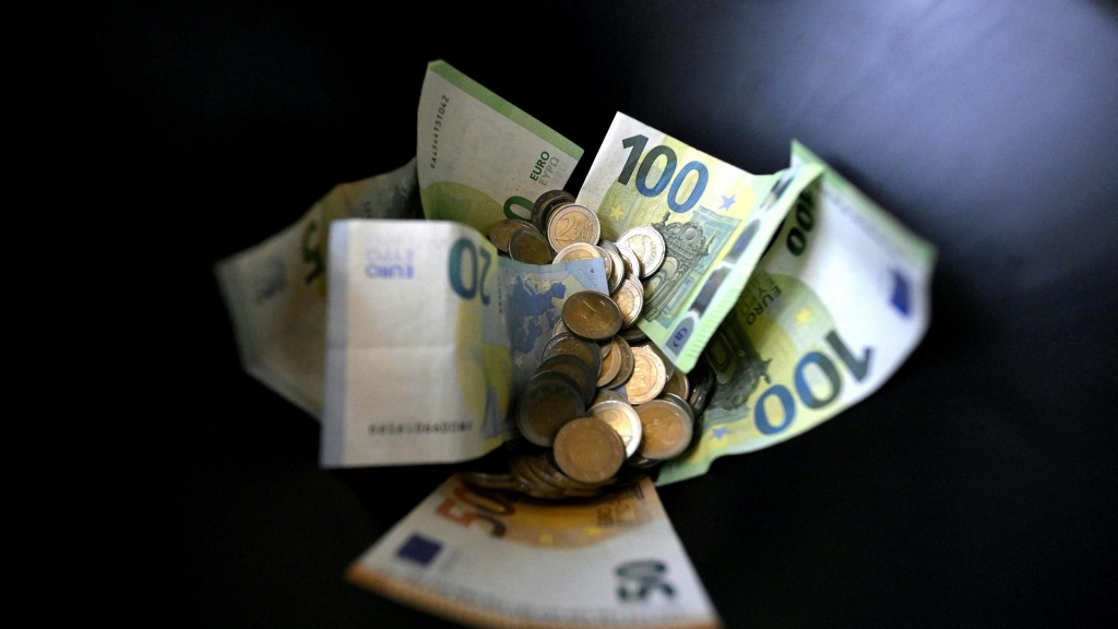 Münzen und Geldscheine vor einem schwarzen Hintergrund (Symbolbild)