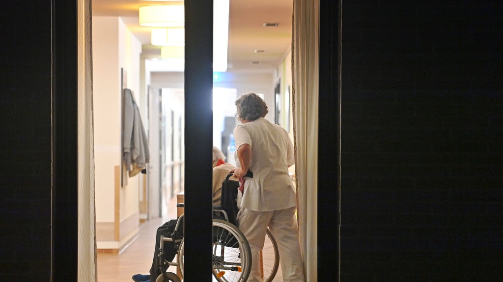 Foto: Pflegekraft schiebt eine Person im Rollstuhl