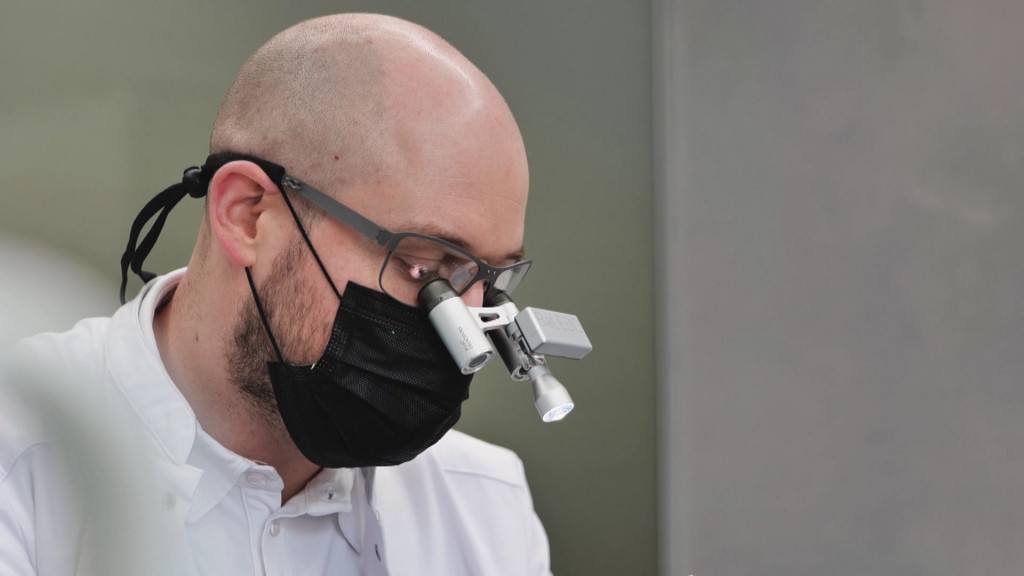 Foto: Arzt mit Mundschutz und Vergrößerungsglas