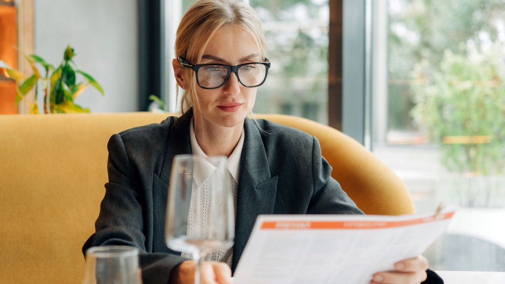 Foto: Eine Frau sitzt in einem Restaurant und liest die Speisekarte