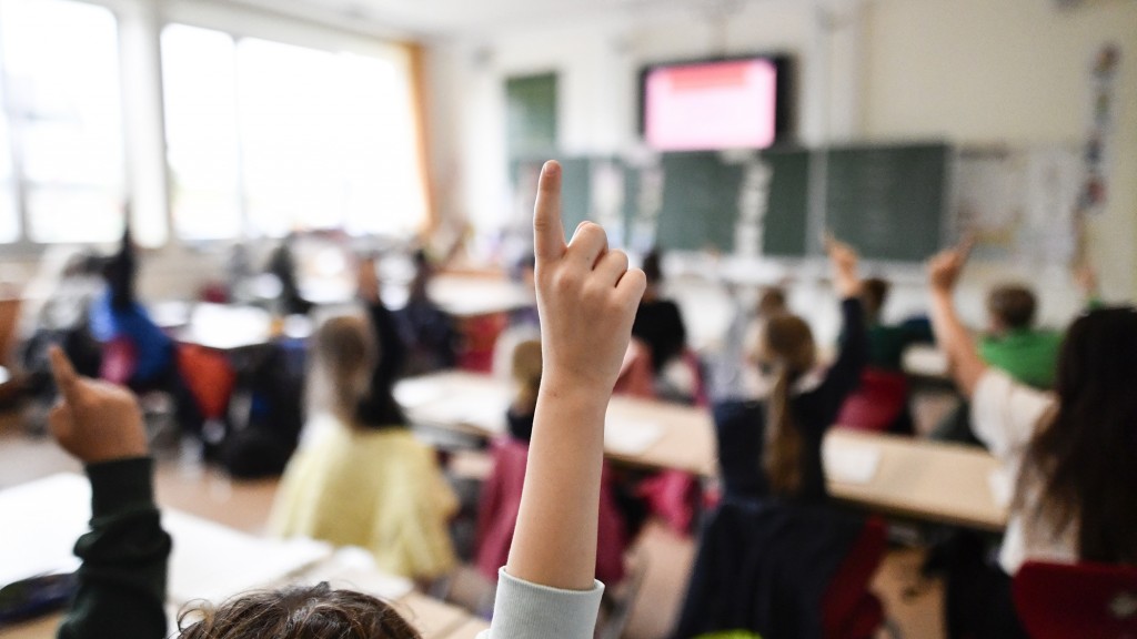 Unterricht in einer Grundschule. Eine Schülerin melden sich.