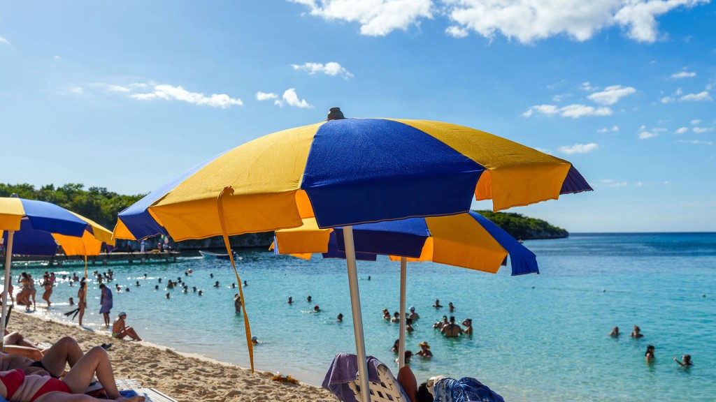 Menschen und Sonnenschirme an einem sommerlichen Badestrand