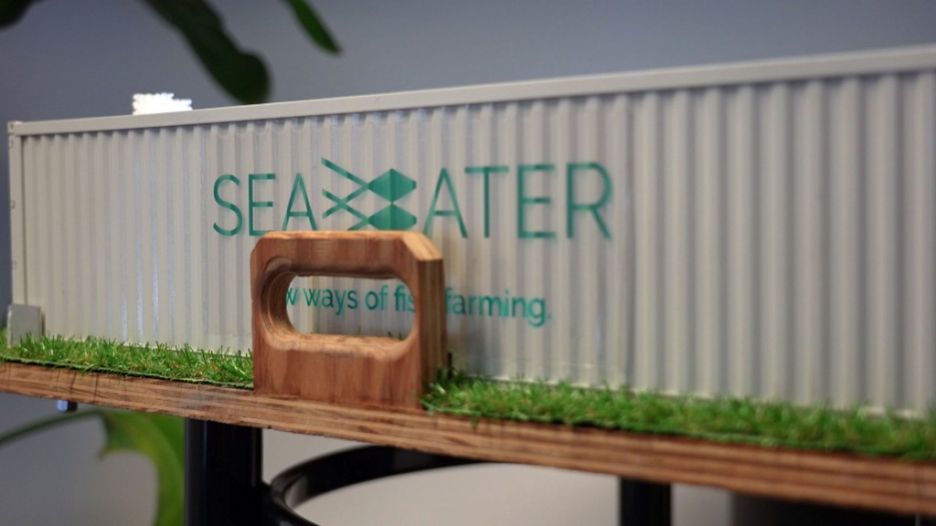 Logo der Seawater Cubes GmbH auf dem Tisch-Modell eines Seewasserfischzuchtcontainers