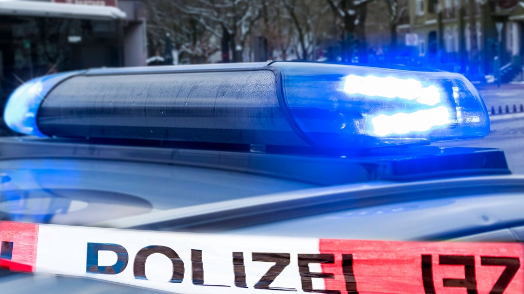 Polizeiabsperrung vor einem Einsatzwagen mit Blaulicht