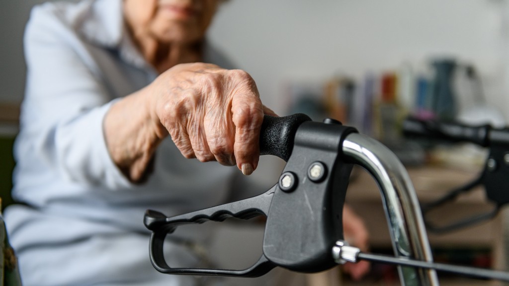 Foto: Eine Seniorin hält sich an ihrem Rollator fest. 