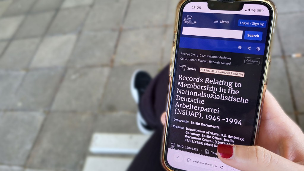 Foto: Person hält Handy mit geöffneter Archiv-Seite in der Hand