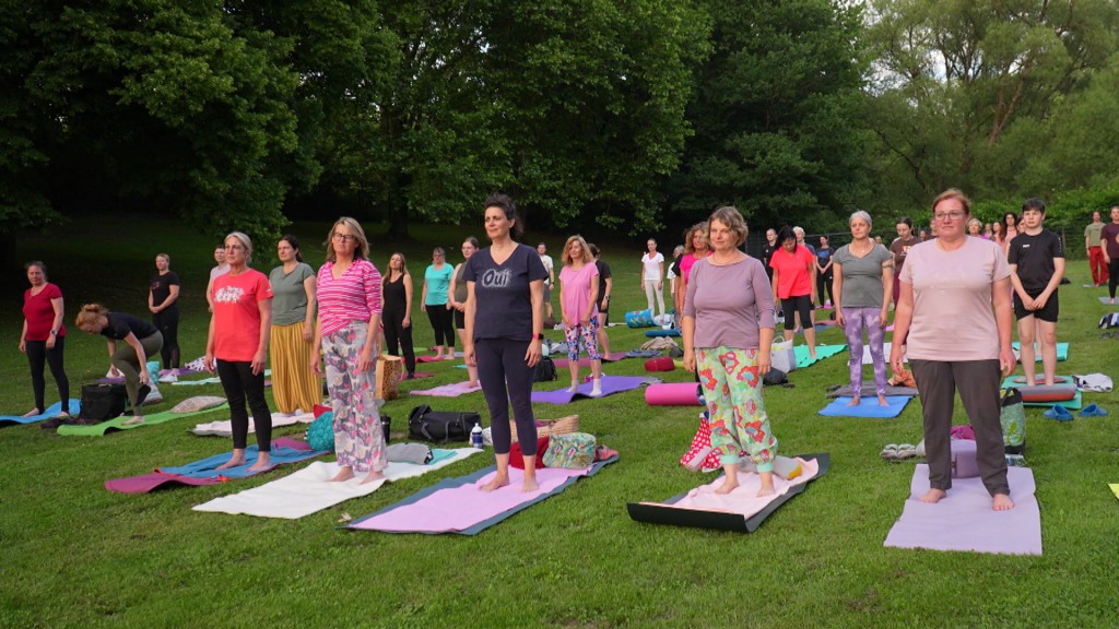Foto: Eine Gruppe Menschenim Freibad beim Outdoor-Yoga