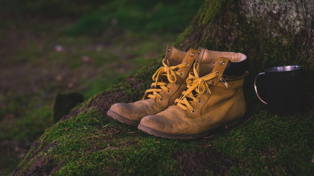 Gelbe Wanderschuhe stehen auf grünem Moos im Wald