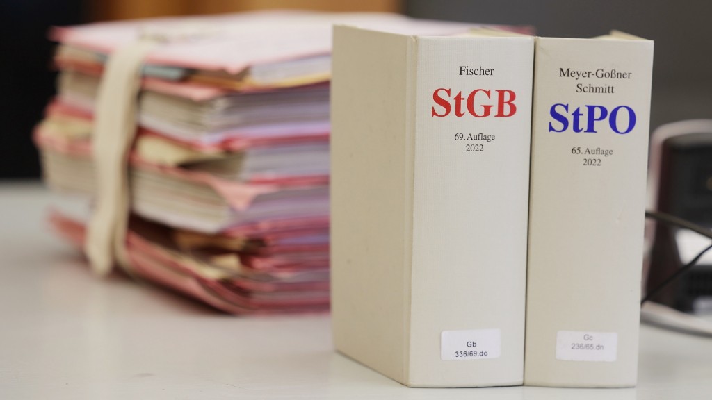 Gerichtsakten und Bücher zu Strafgesetzbuch und Strafprozessordnung liegen bzw. stehen liegen auf einem Tisch im Gericht