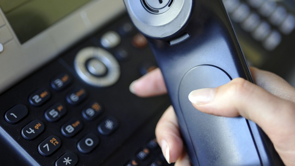 Eine Frau hält einen Telefonhörer in der Hand