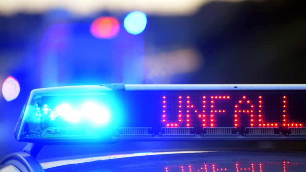 Auf einem Polizeifahrzeug warnt eine Leuchtschrift vor einer Unfallstelle.