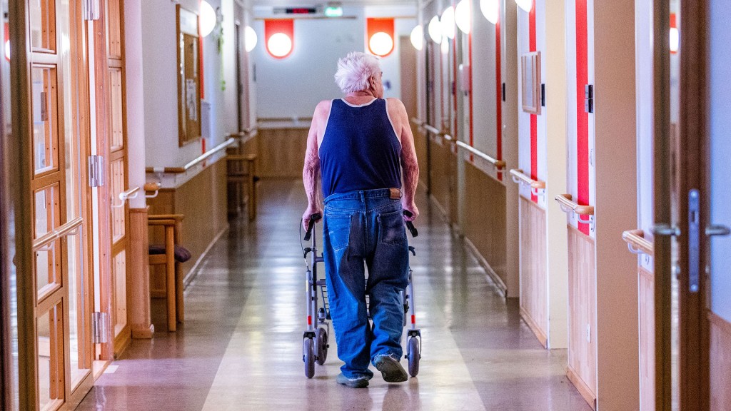 Foto: Ein Bewohner mit seinem Rollator im Flur eines Pflegeheimes