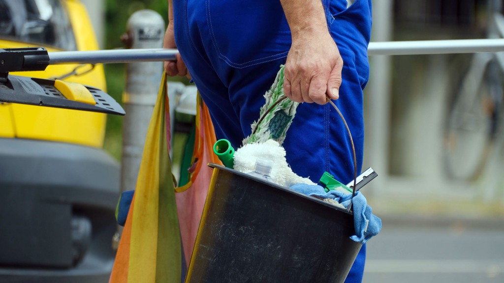 Foto: Eine Reinigungskraft mit Putzeimer und Wischlappen