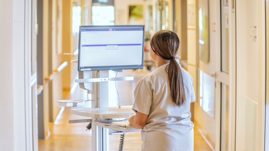 Foto: Eine medizinische Fachkraft an einen mobilen Computerarbeitsplatz im Krankenhausflur