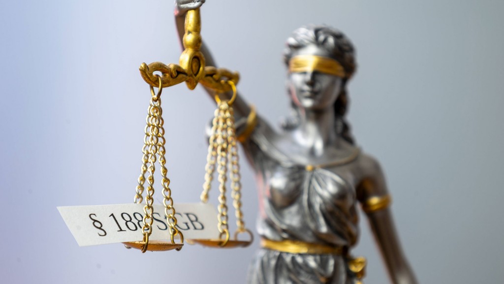 Symbolbild: Nahaufnahme einer Justitia mit einem Schild mit der Aufschrift § 188 StGB, dem sogenannten Beleidigungsparagraphen