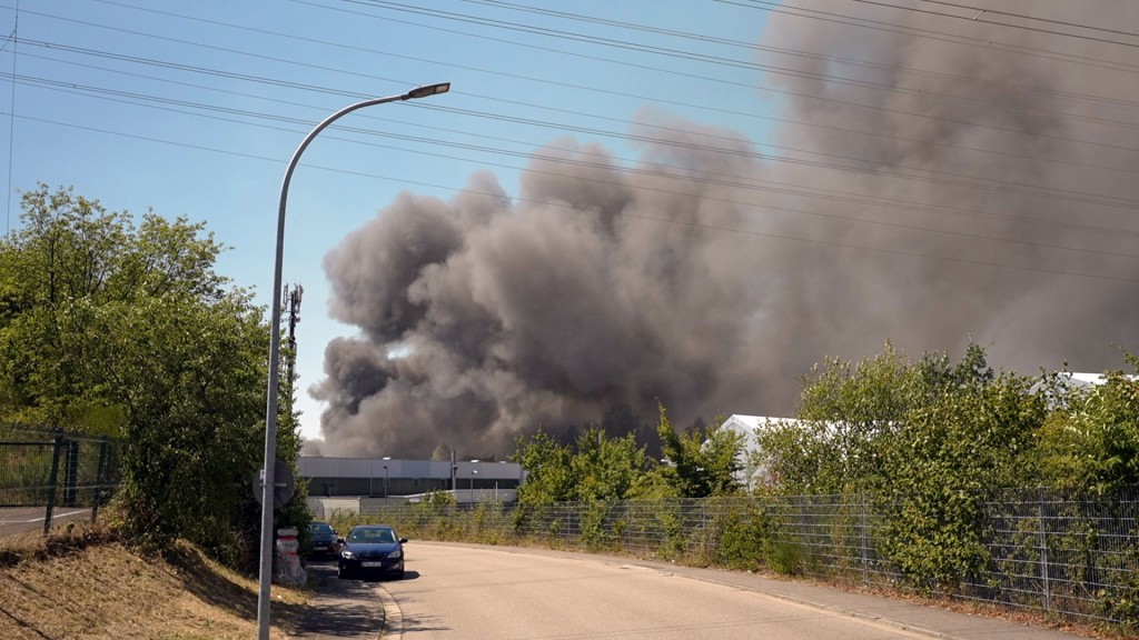 Foto: Eine dichte Rauchwolke steht über dem Brand einer Lagerhalle in Neunkirchen