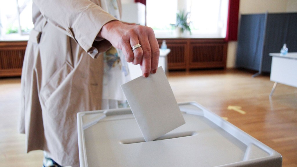 Foto: Frau wirft ihren Stimmzettel in die Wahlurne.