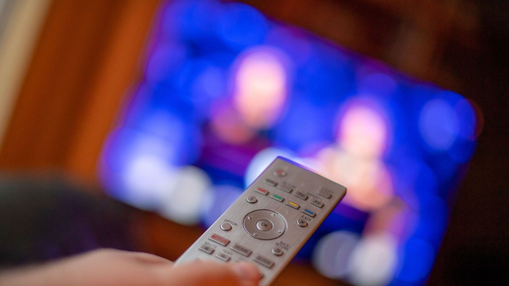 Jemand hält eine Fernbedienung auf einen Fernseher