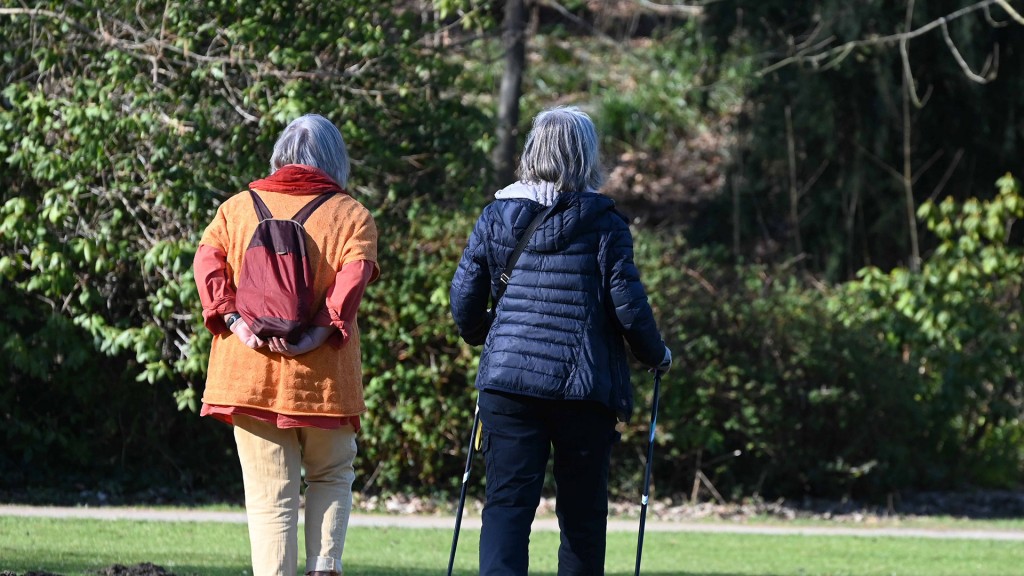 Foto: Zwei Seniorinnen gehen im Park spazieren