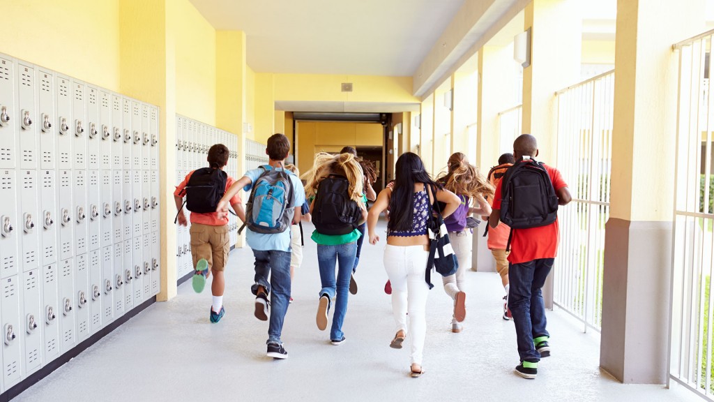 Mehrere Schülerinnen und Schüler laufen über den Flur zum Klassenraum