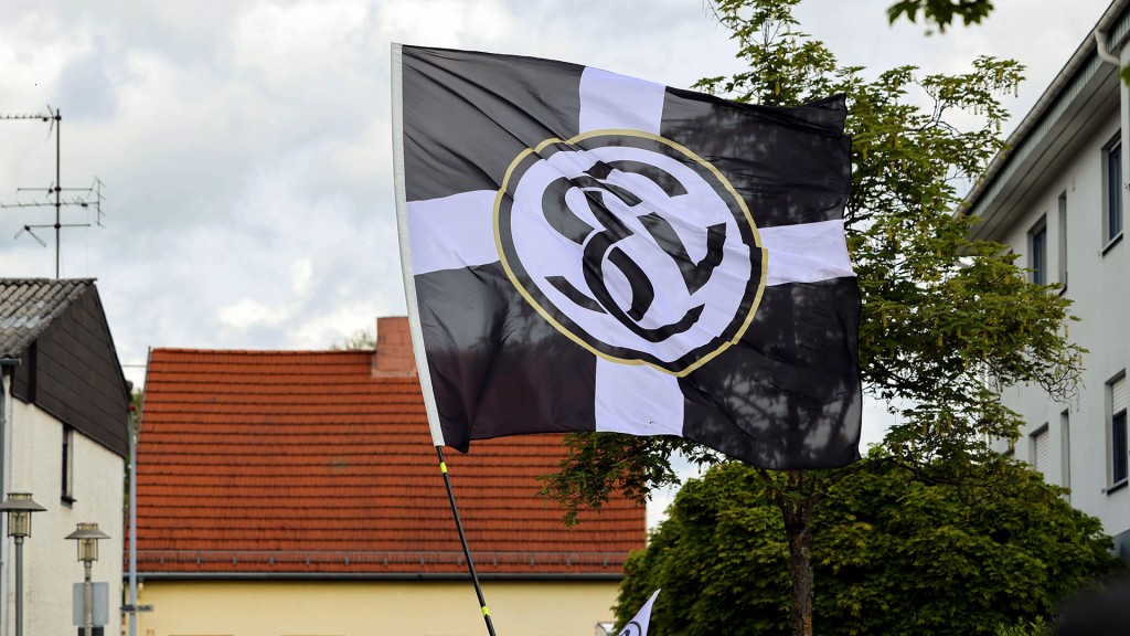 Fans der SV Elversberg schwenken eine Fahne des Vereins