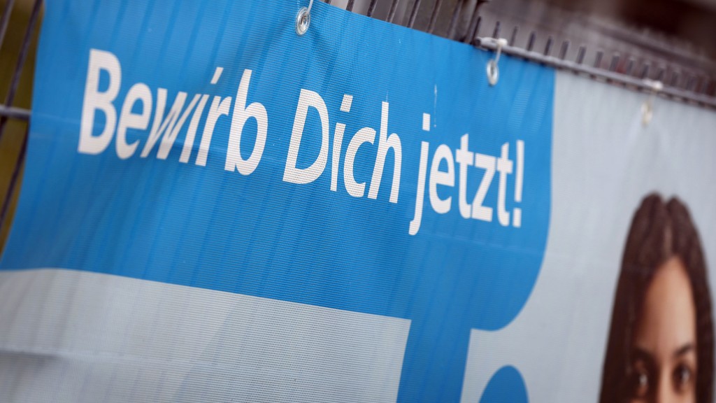 «Bewirb dich jetzt» ist auf einem Banner am Zaun einer Firma zu lesen