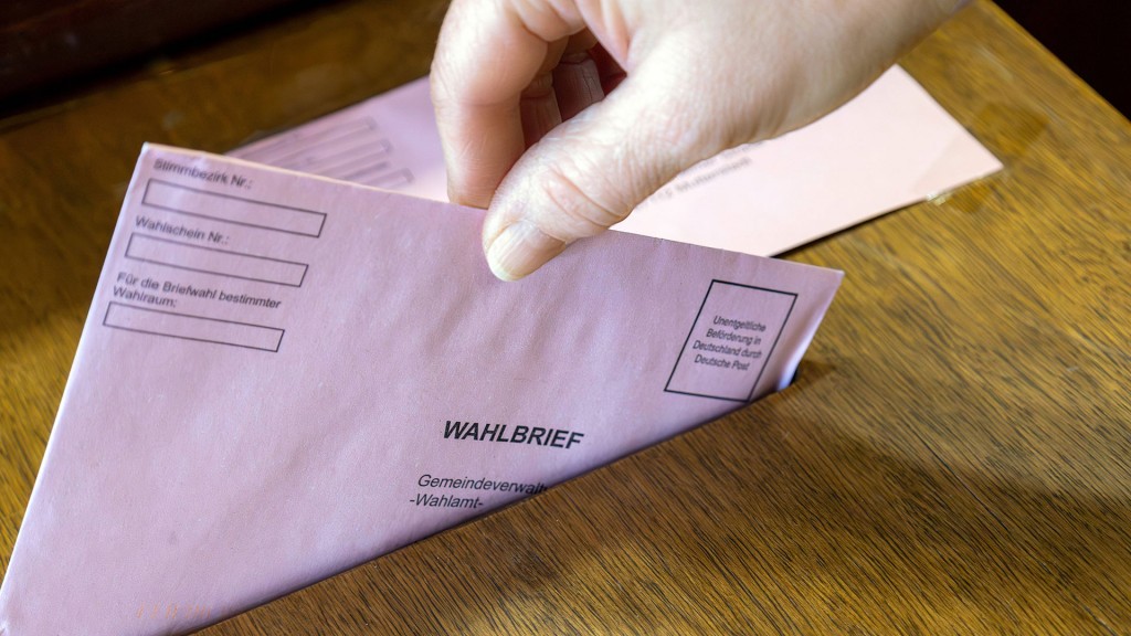 Foto: Ein Wahlbrief wird in die Wahlurne eingeworfen.